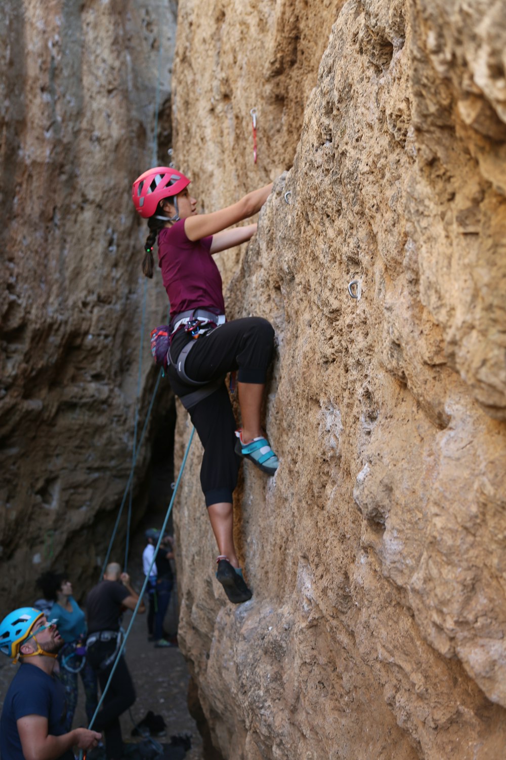 a woman climbing up a steep rock face