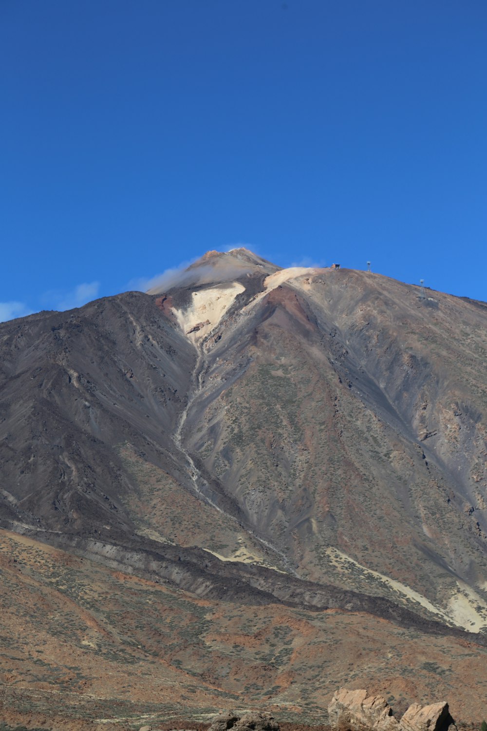 a very tall mountain with a few clouds in the sky