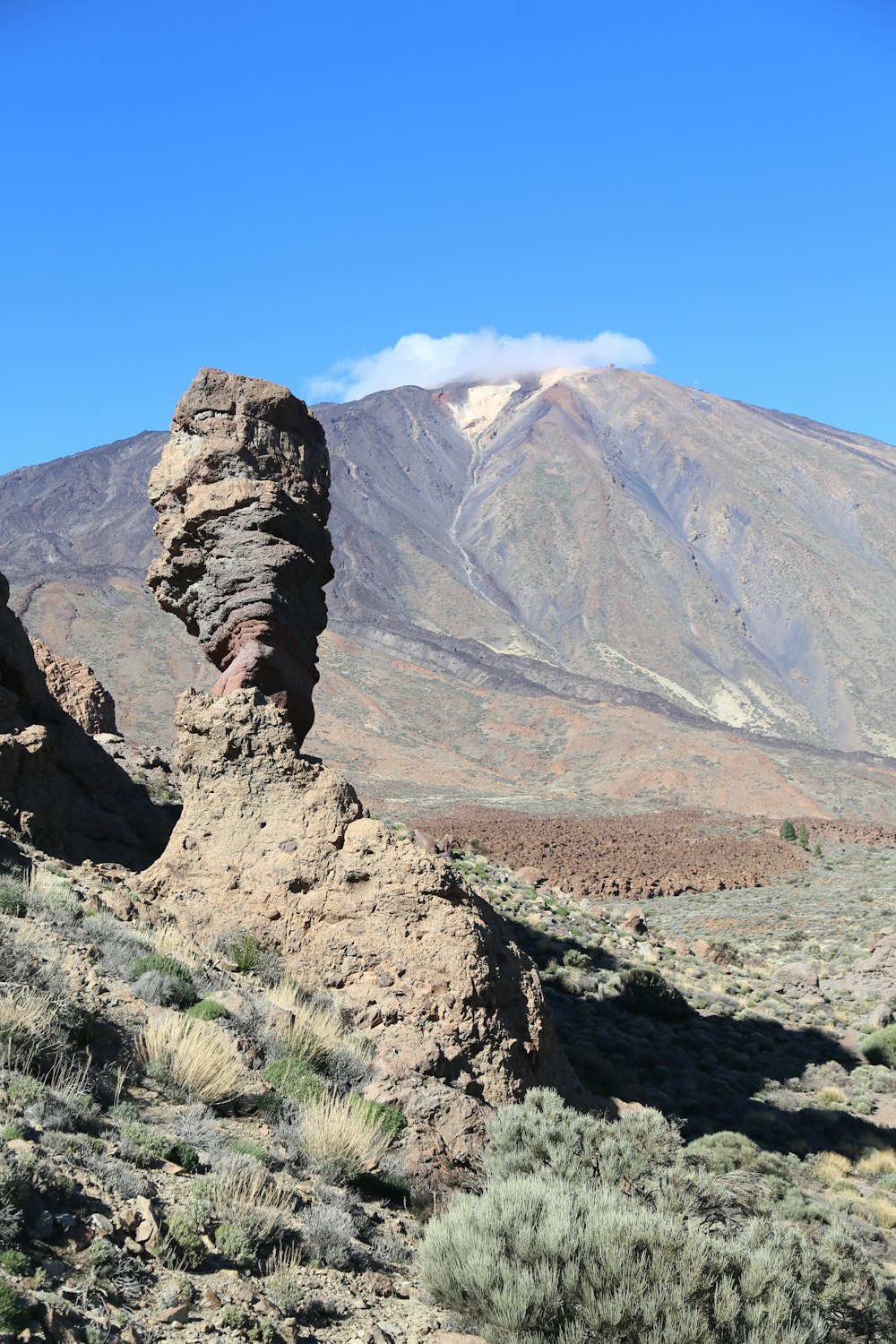 a rock formation in the desert with a mountain in the background