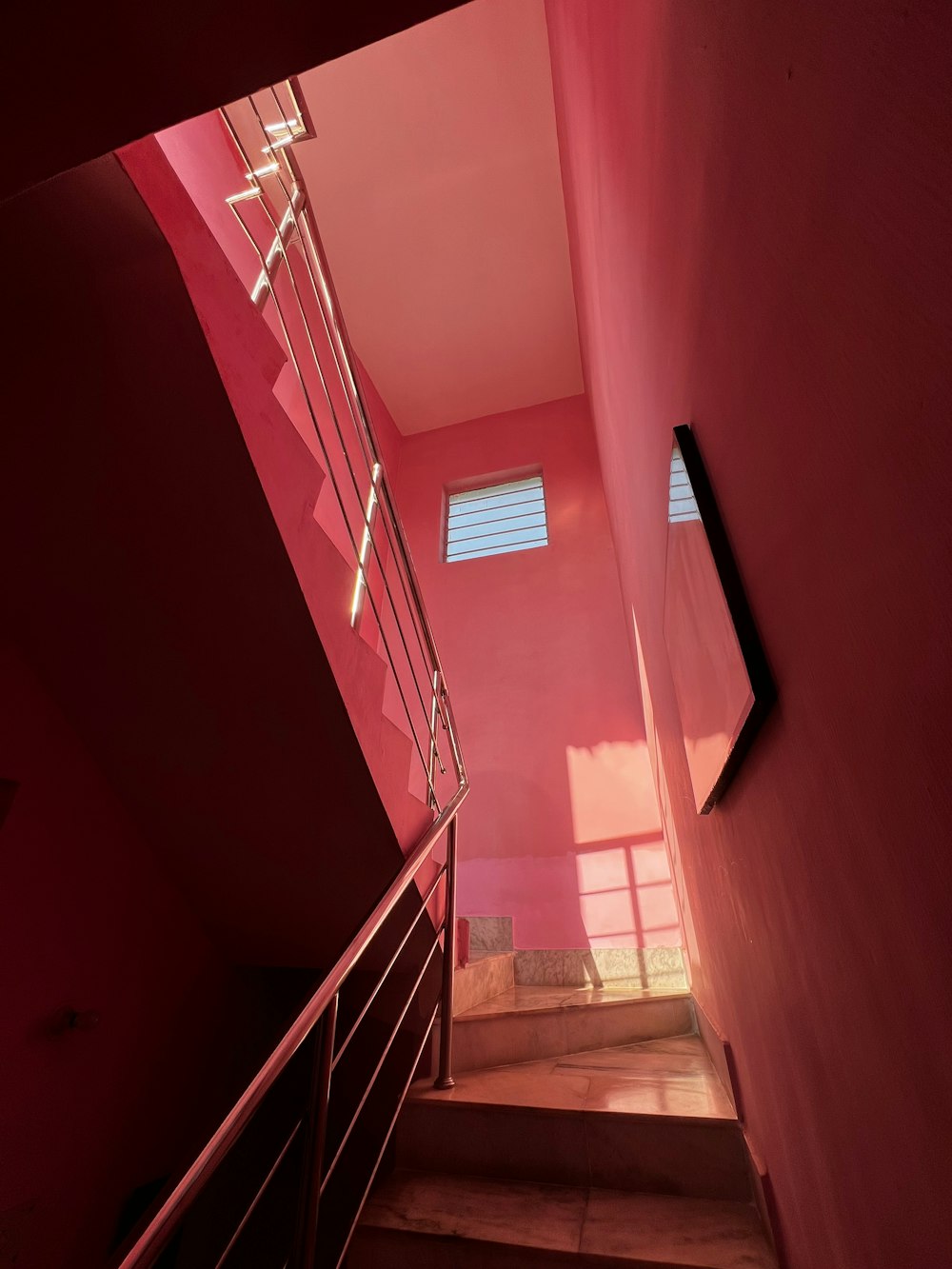 a stairwell with a red wall and a window