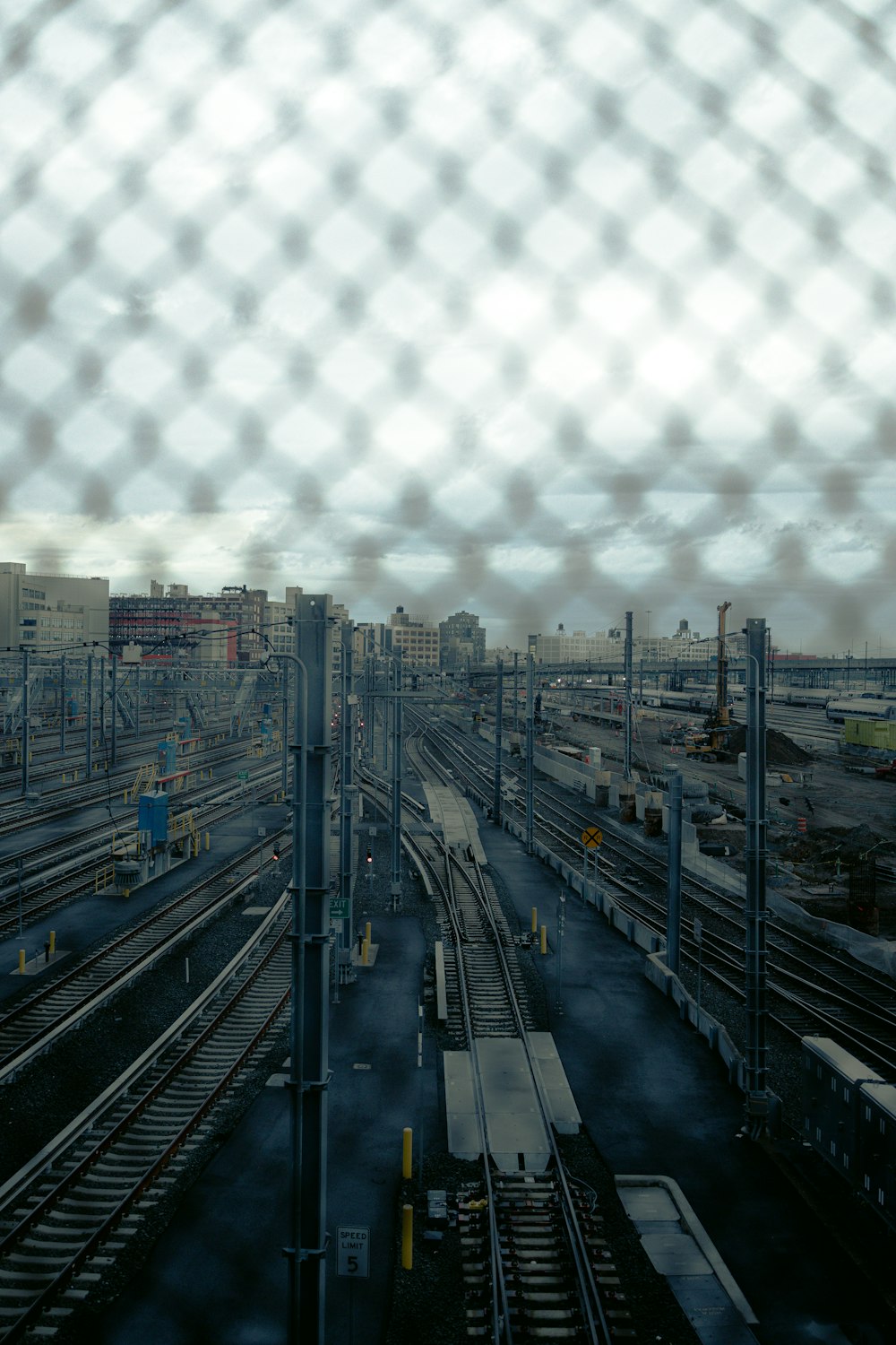 a view of a train yard through a fence