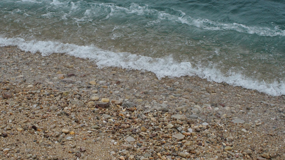 a sandy beach with a wave coming in to shore