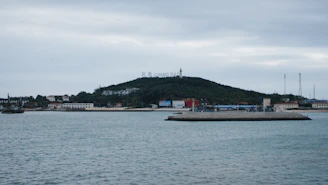 a body of water with a hill in the background