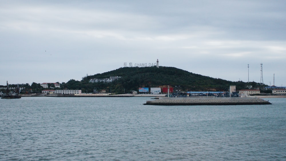 a body of water with a hill in the background