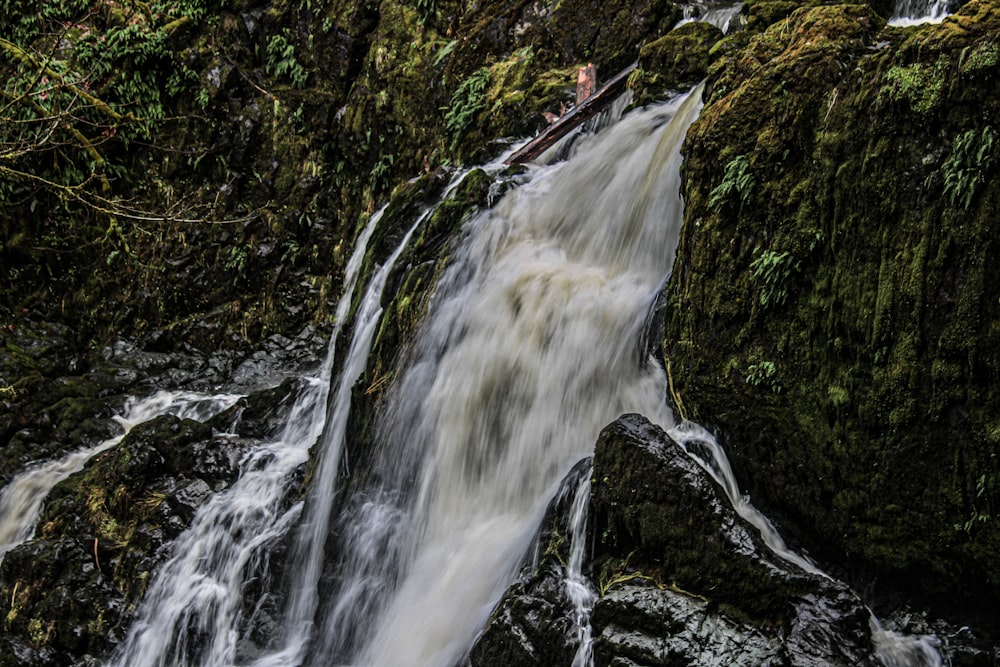 un homme debout au sommet d’une cascade