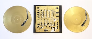 Golden vinyl records and stereo equipment styled on a black surface, reflecting DJ Claude’s premium aesthetic