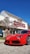 A satisfied customer with their new car, smiling in front of the dealership.