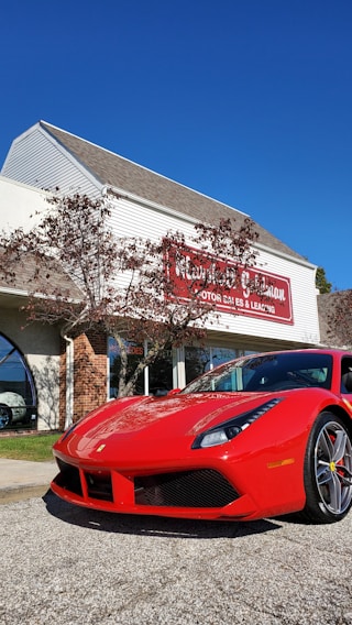 A bright red used sedan parked in front of Simple Auto Sales with a clear blue sky overhead.