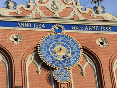 a large blue and gold clock on the side of a building