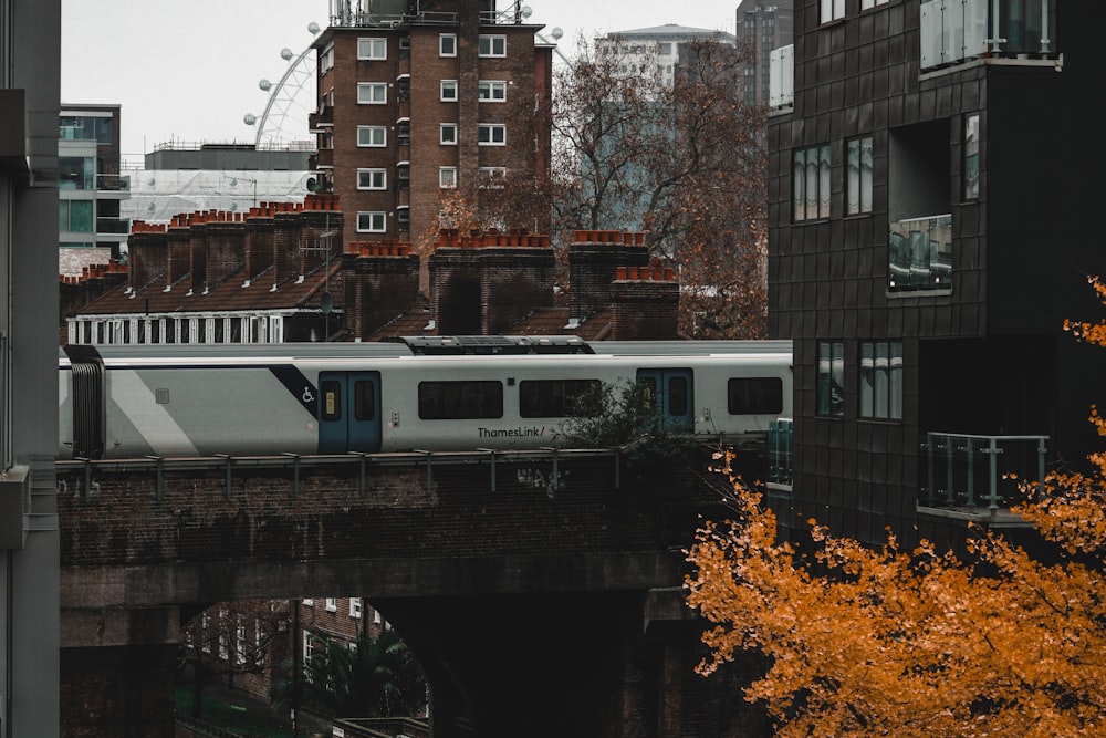 a train traveling over a bridge next to tall buildings