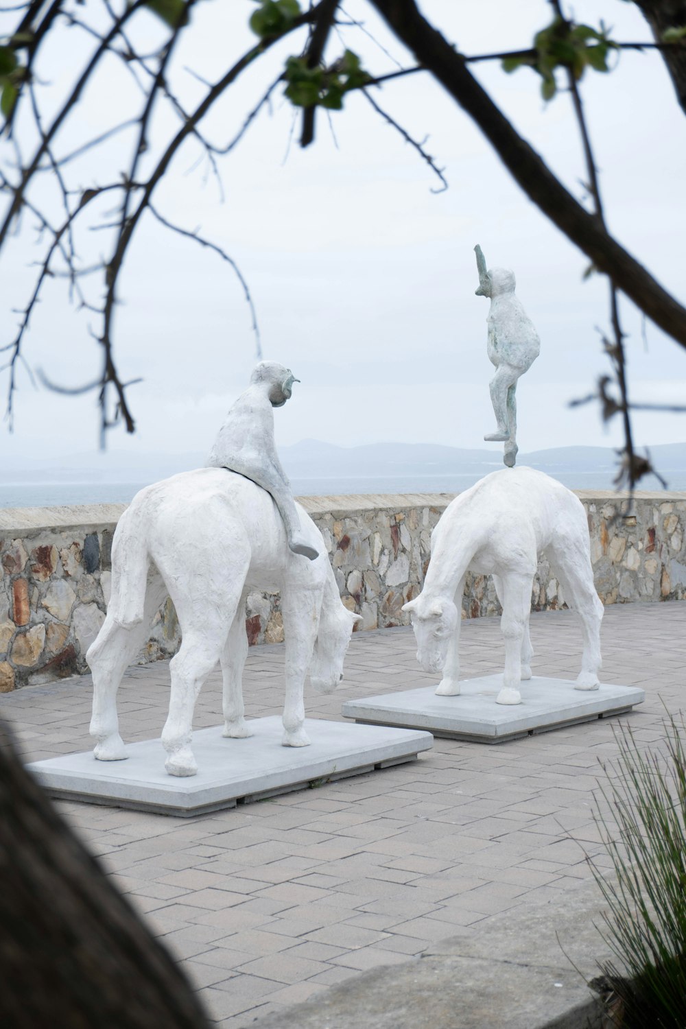 Un par de estatuas blancas sentadas sobre bloques de cemento