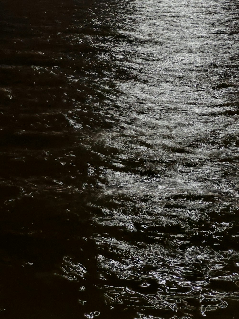 a large body of water with a boat in the distance