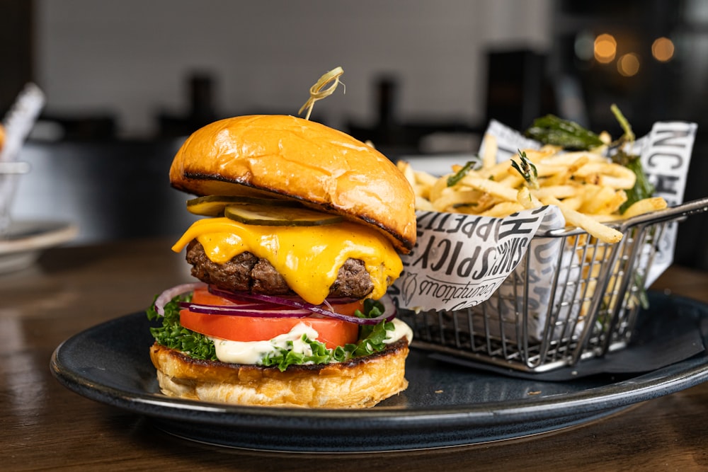 a cheeseburger on a plate with a basket of fries