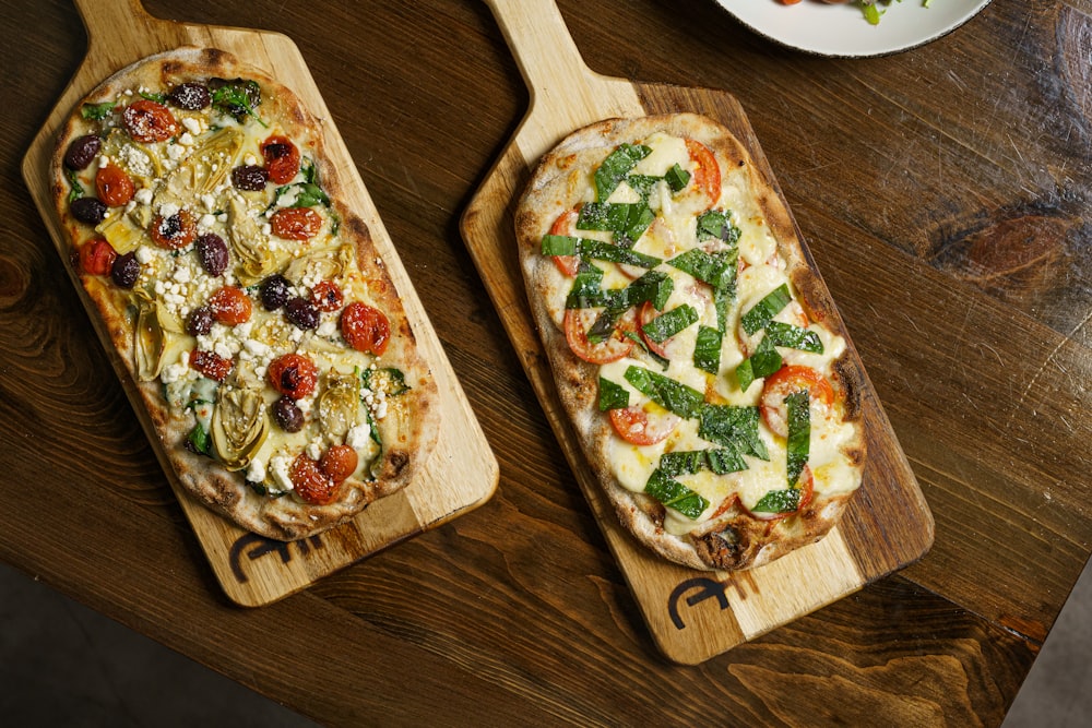 quelques pizzas posées sur une planche à découper en bois