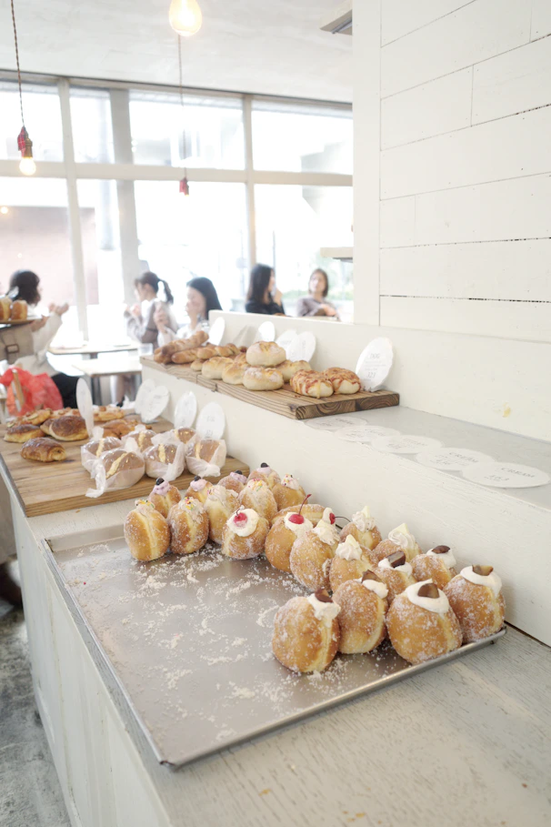 A warm, colorful bakery counter filled with artisan breads and pastries, sunlit by morning light.