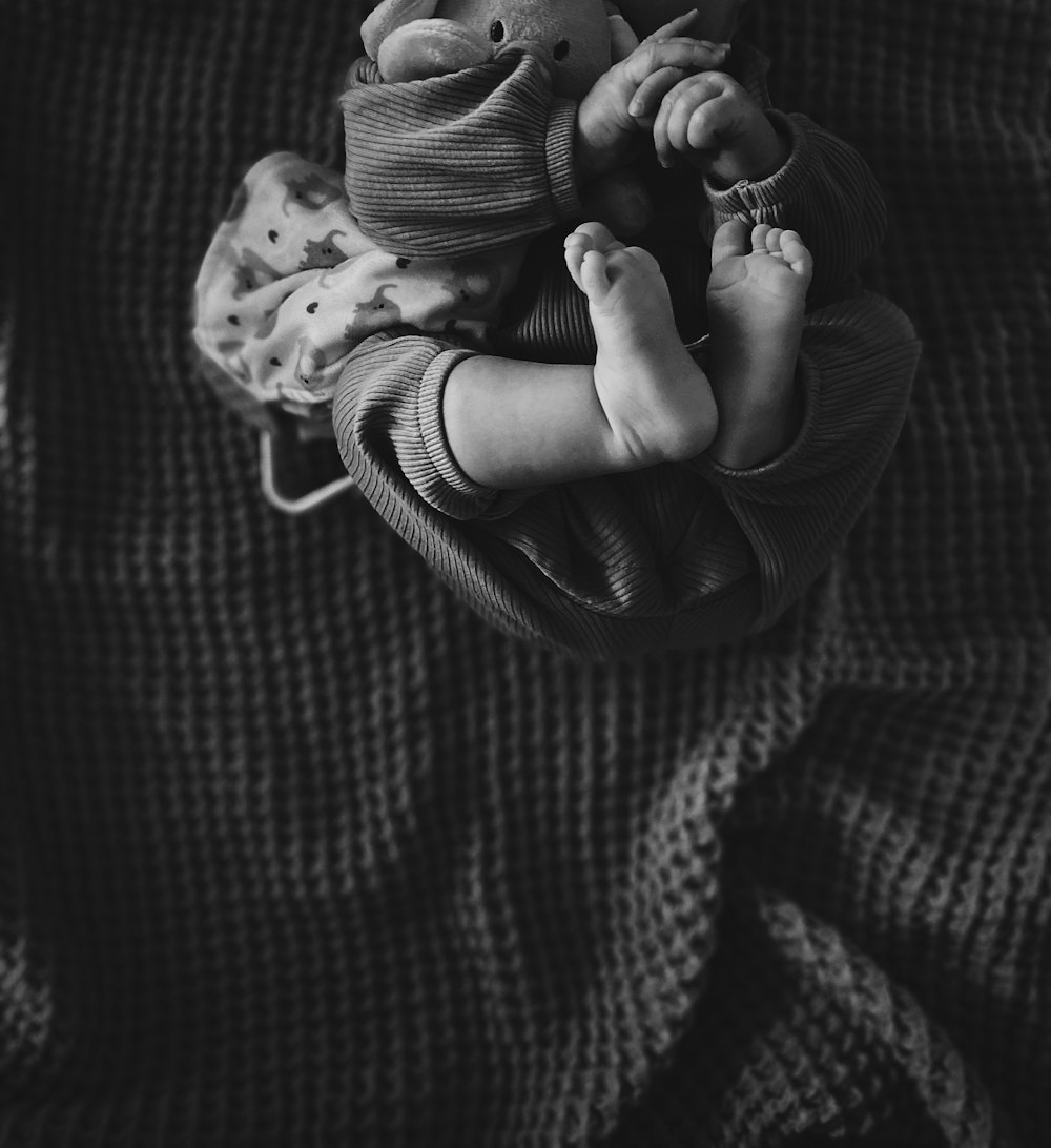 a black and white photo of a baby wrapped in a blanket