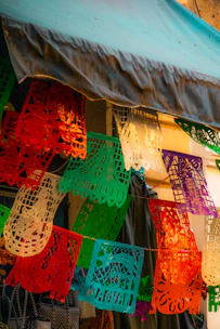 Close-up of intricate floral patterns cut into vibrant papel picado sheets