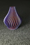 a purple vase sitting on top of a gray floor