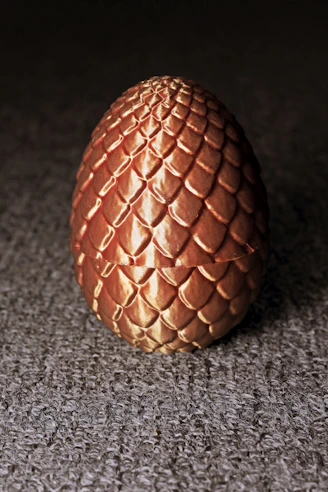 a golden dragon egg sitting on a carpet