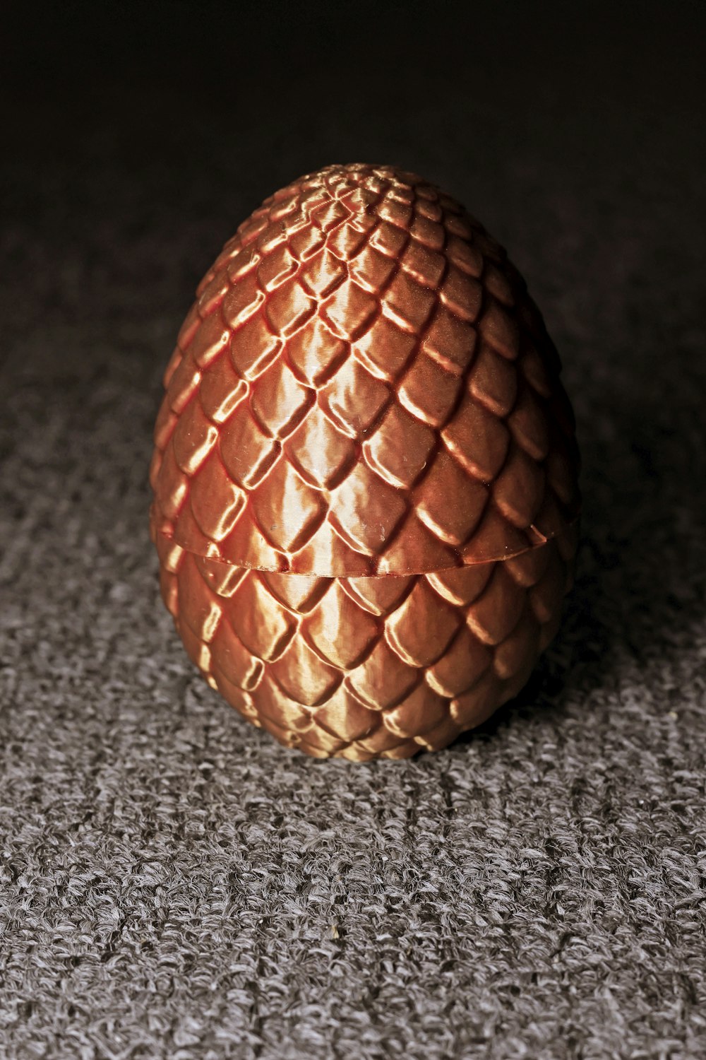 a golden dragon egg sitting on a carpet