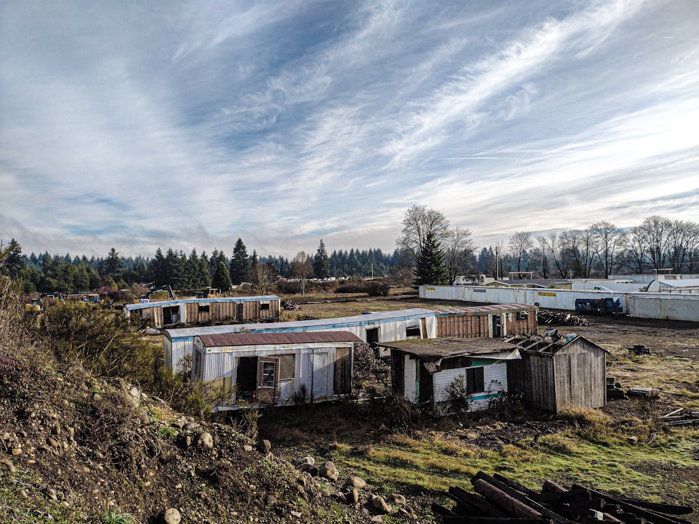 a group of shacks sitting on top of a grass covered hillside