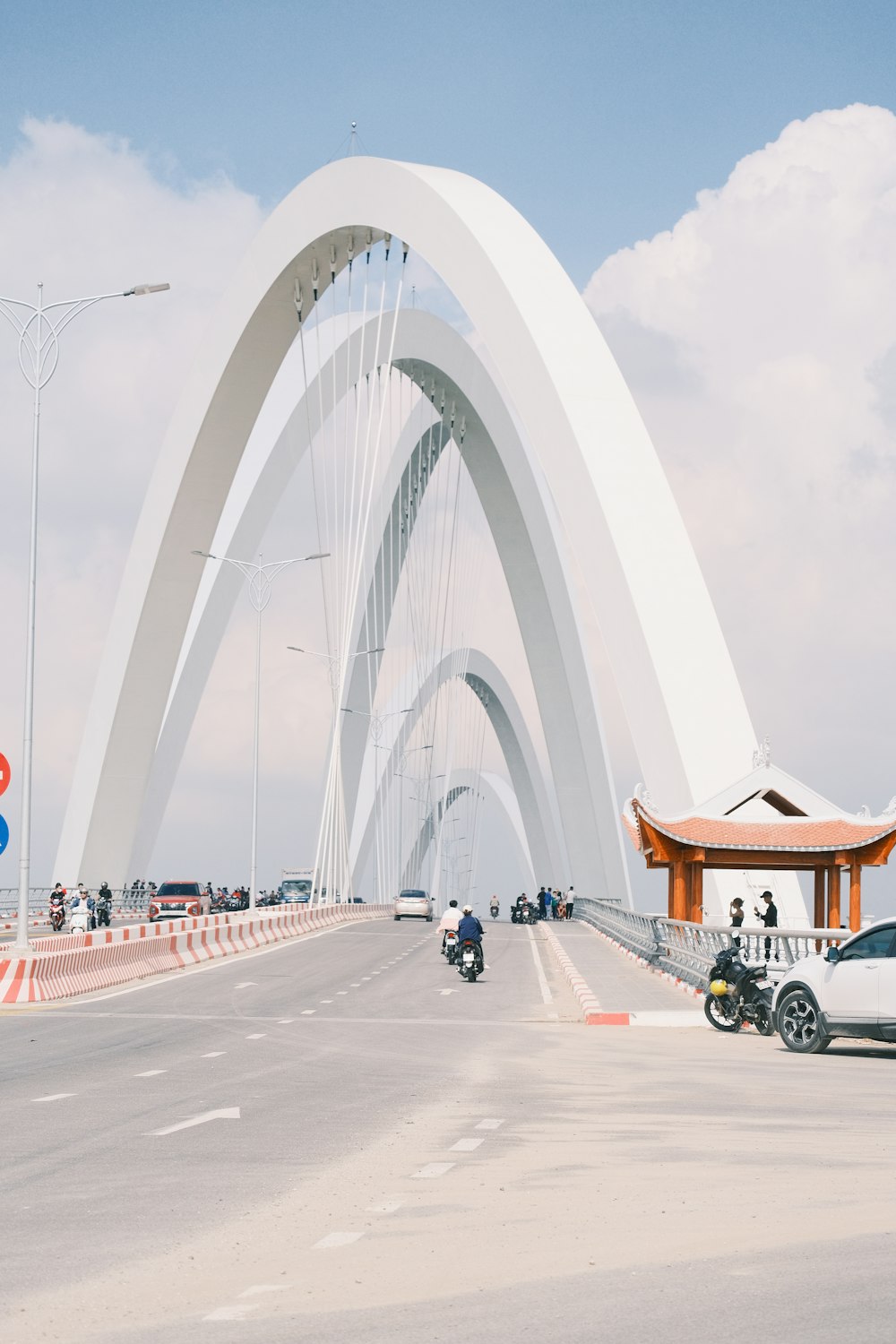 a large white arch over a road with cars driving on it