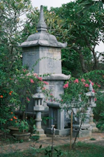 A serene view of the stone pinwheel monument surrounded by lush greenery in the park.