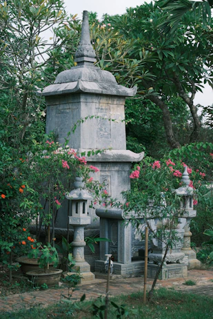A serene view of the stone pinwheel monument surrounded by lush greenery in the park.