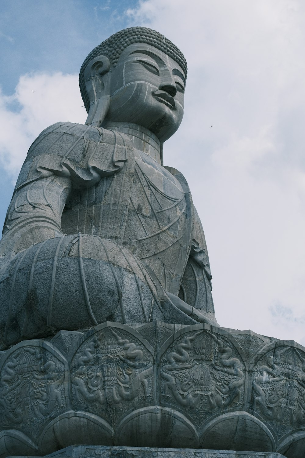 eine große Buddha-Statue, die auf einer Bank sitzt
