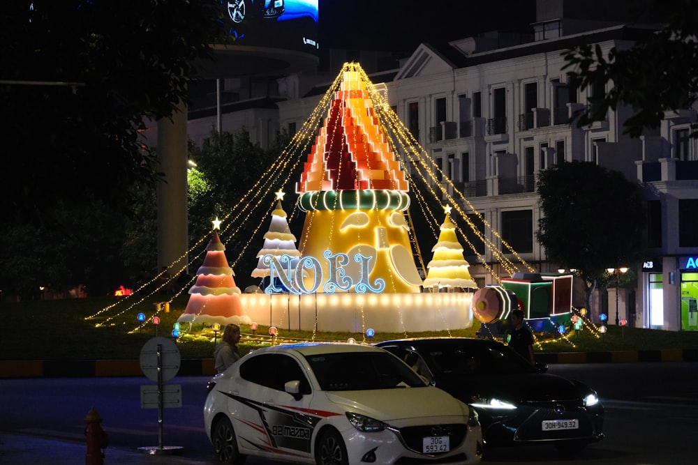 Une voiture est garée devant un spectacle de lumières de Noël
