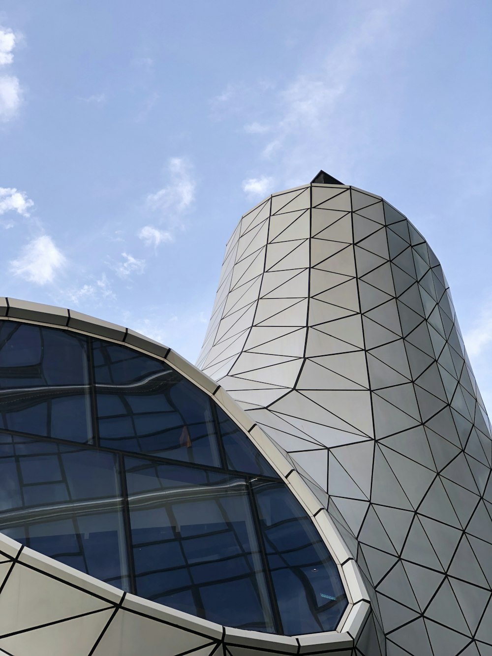 a building with a curved roof and a sky background