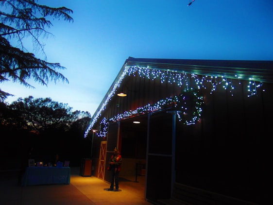 A friendly ZMK Enterprises technician performing maintenance on a cozy rental property at dusk.