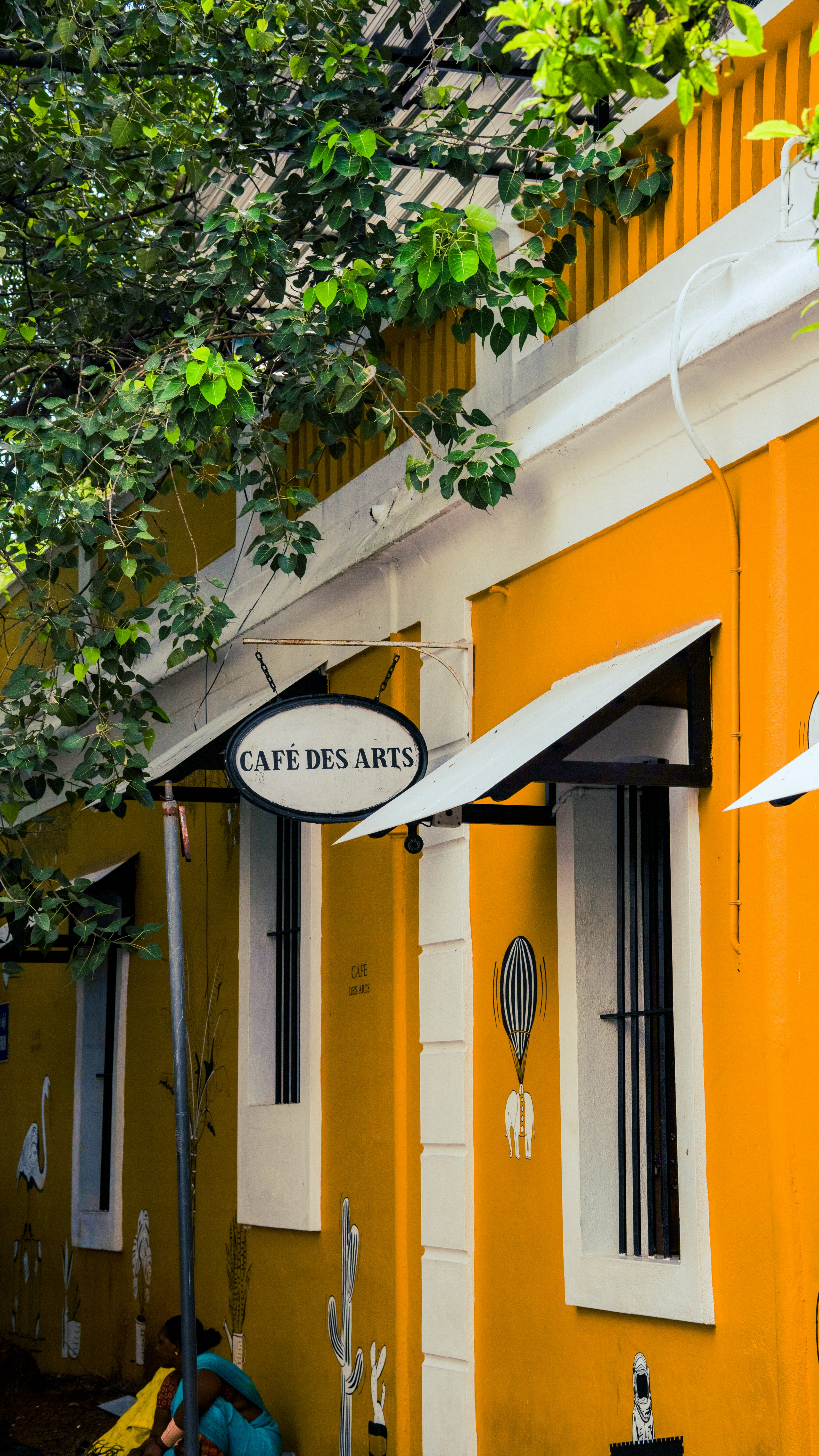 A yellow building with a sign that says cafe des art