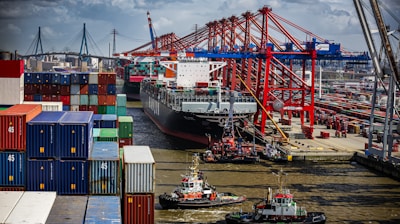 a tug boat in the water next to a large cargo ship