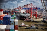 a tug boat in the water next to a large cargo ship