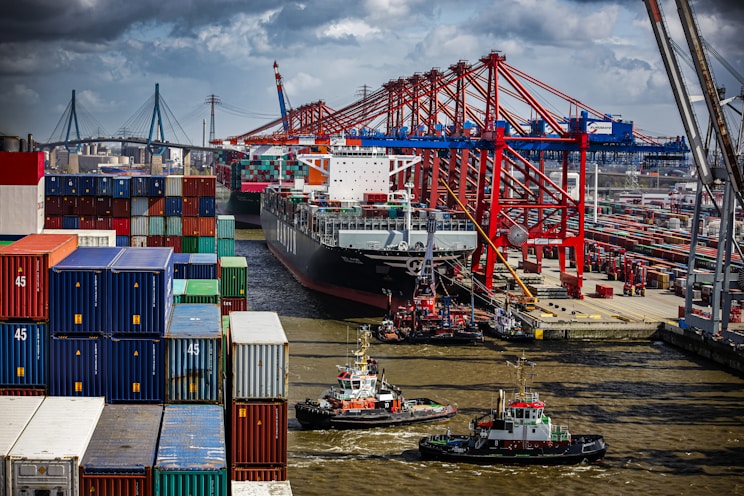 a tug boat in the water next to a large cargo ship