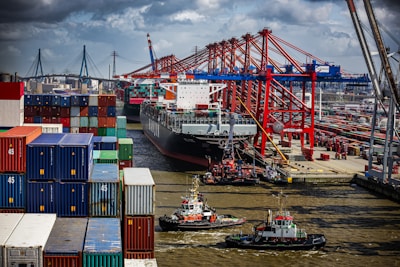 a tug boat in the water next to a large cargo ship