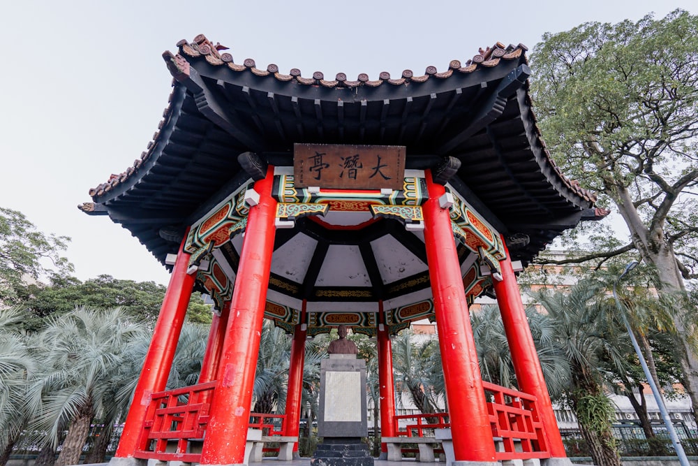 a tall red and black structure with a clock on top of it