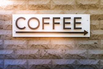 a sign on a brick wall that says coffee