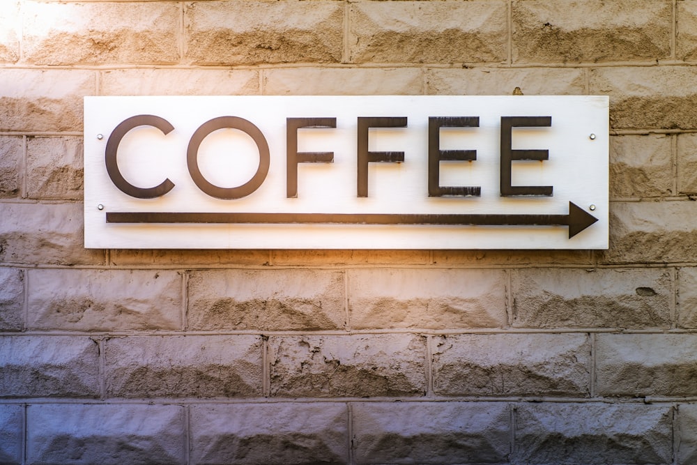 Ein Schild an einer Backsteinmauer mit der Aufschrift Kaffee
