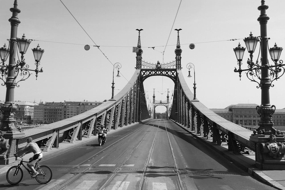 a man riding a bike across a bridge