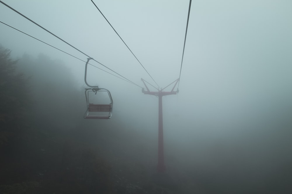 a ski lift in the fog on a mountain