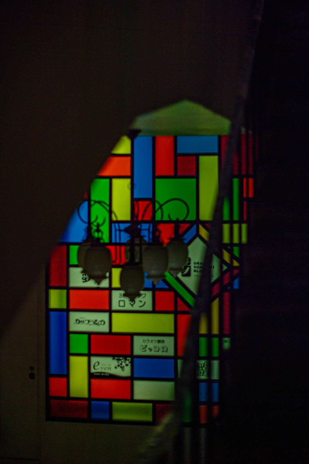 a multicolored stained glass window in a stairwell