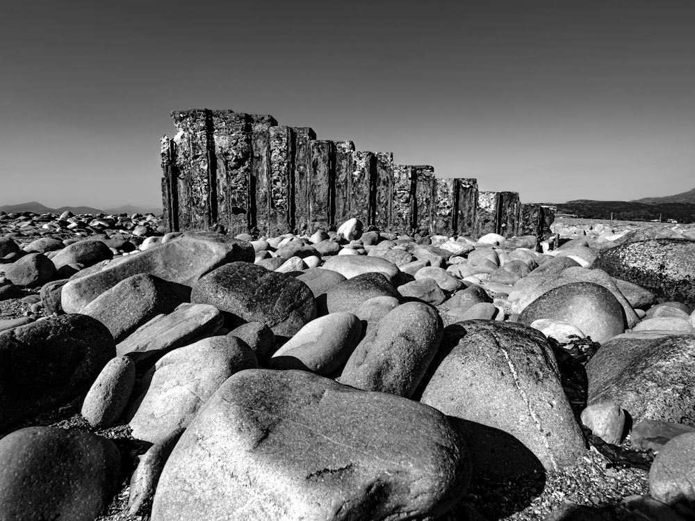 a black and white photo of rocks on the beach