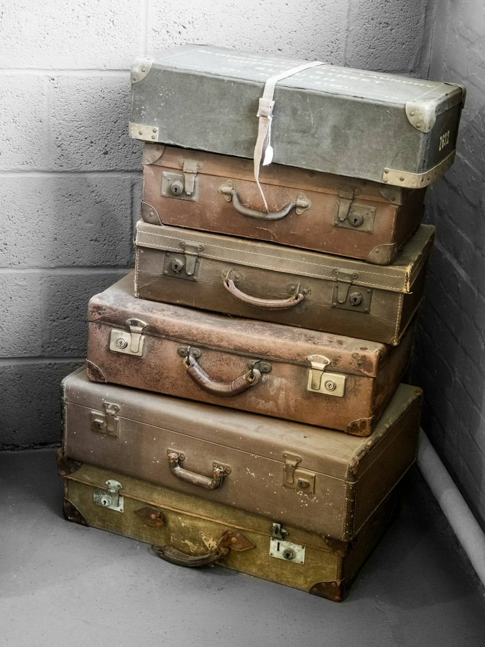 a stack of suitcases sitting next to a brick wall