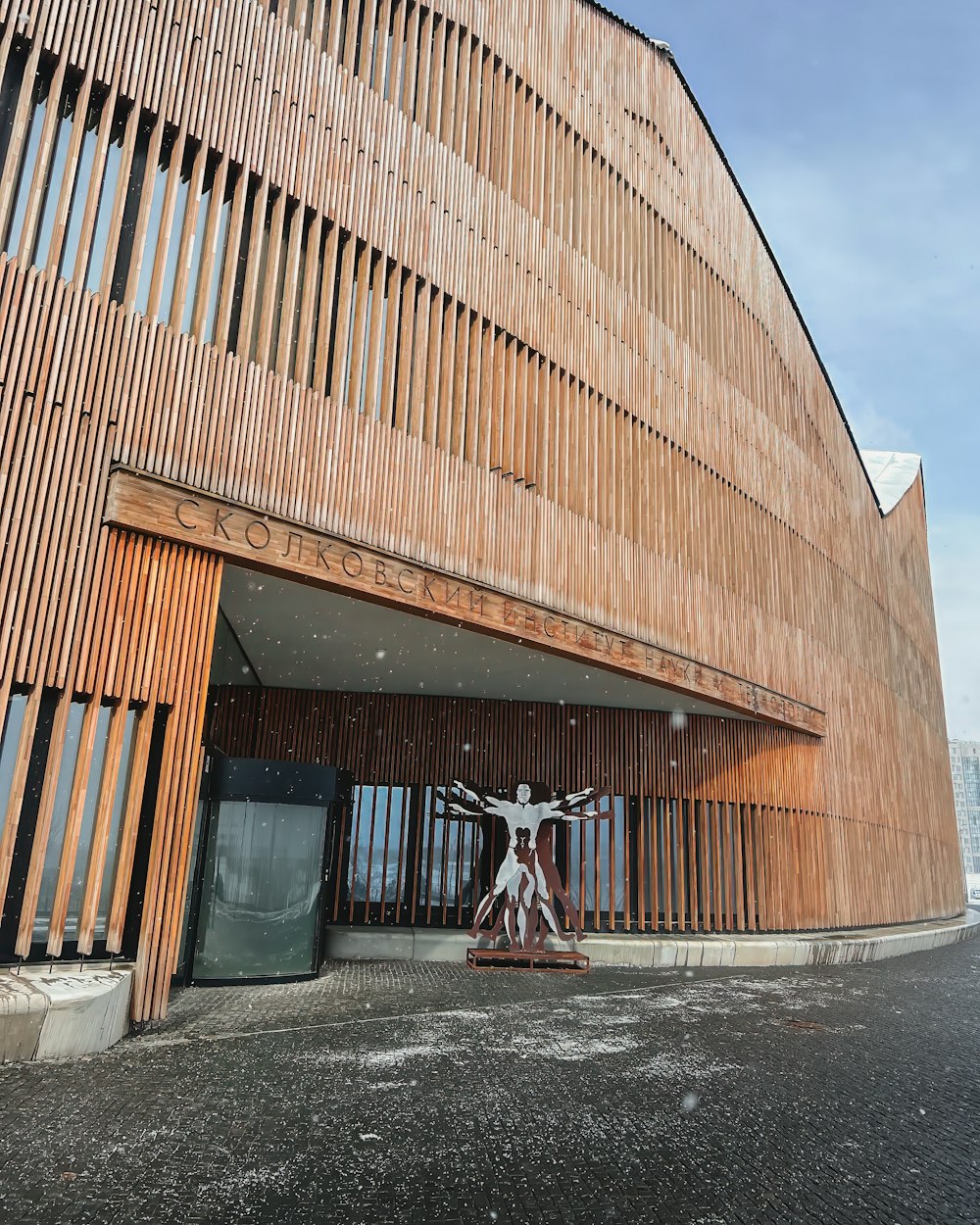 a large wooden building with a statue in front of it