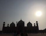 Front view of Shah Jalal Masjid with worshippers entering at dawn.