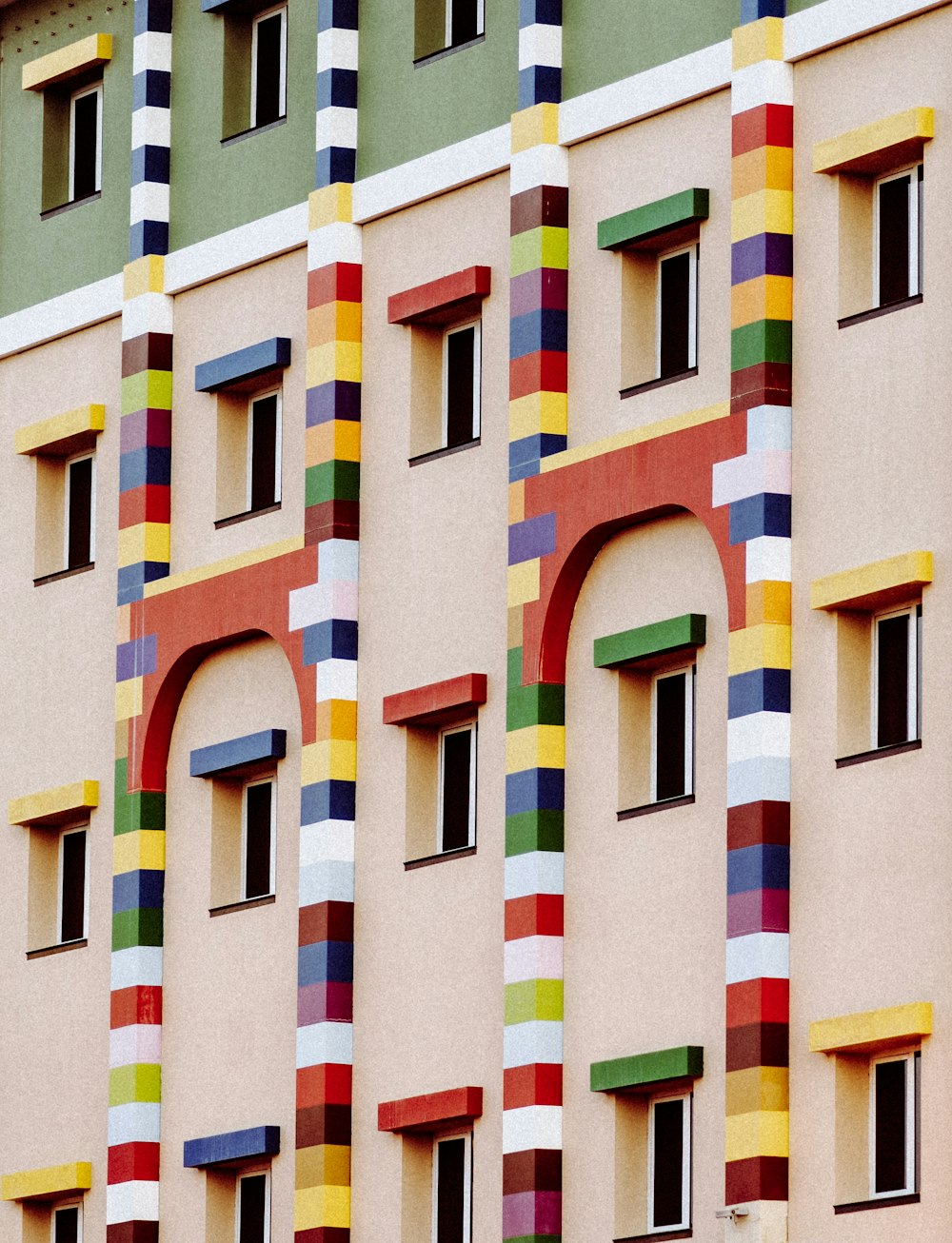 a multicolored building with a clock in front of it