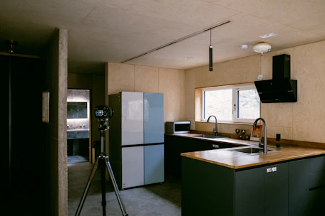 a kitchen with a sink a refrigerator and a tripod