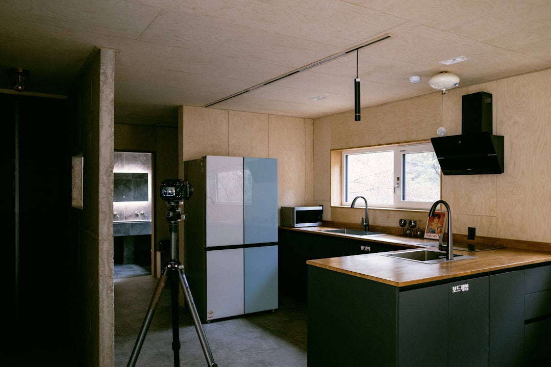 a kitchen with a sink a refrigerator and a tripod,